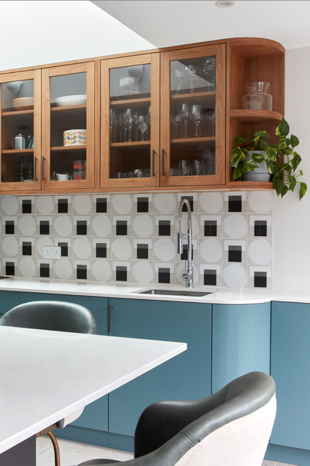 Upper kitchen cabinets in timber finish lower cabinets in blue with black and white tile splash backs