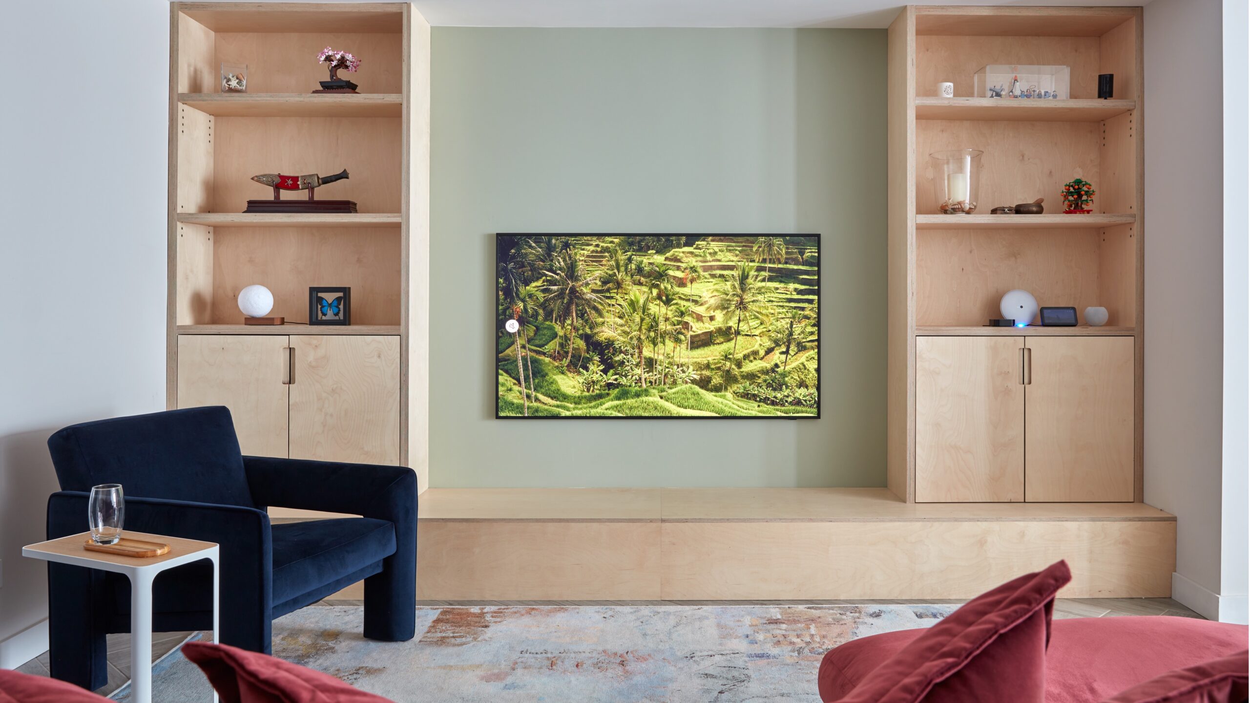 Lounge room with bespoke built in cabinets  , chair cover in velvet, tv shown on wall